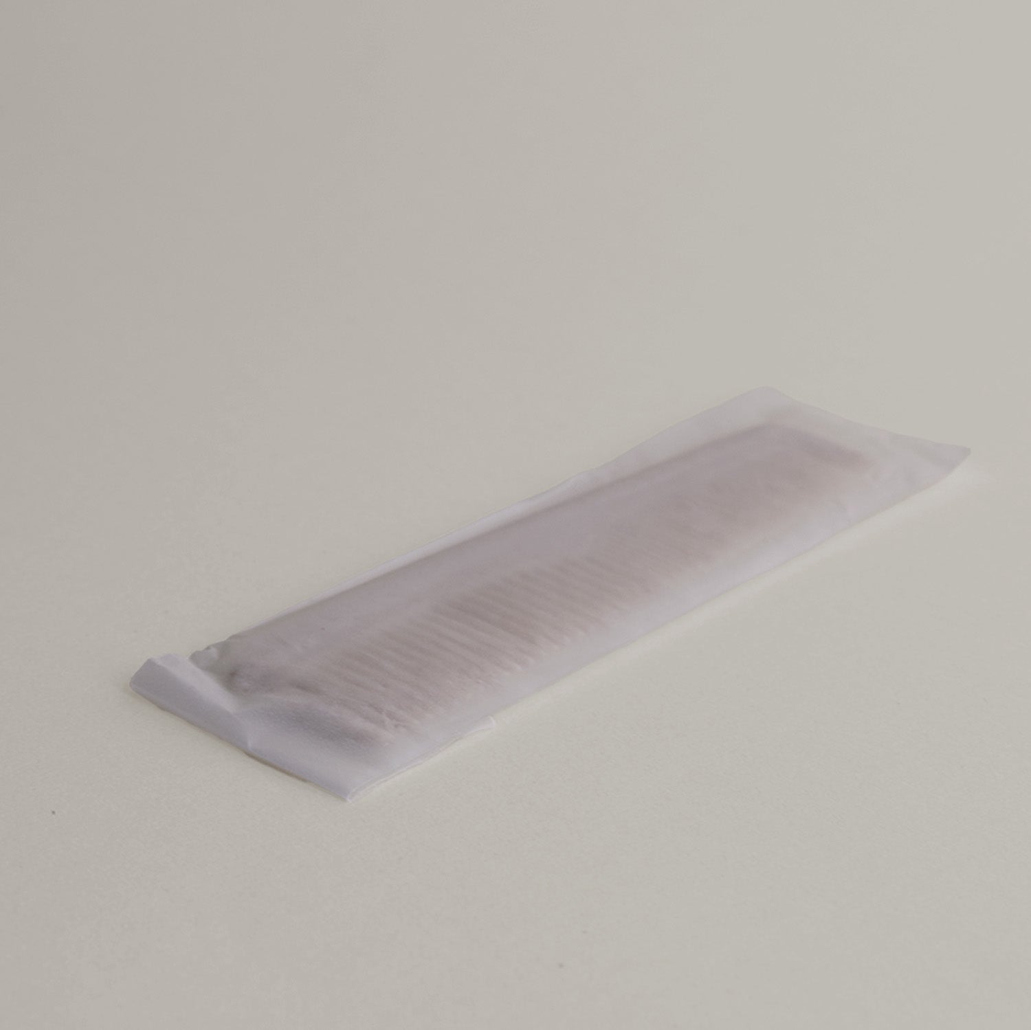 A small plastic hair comb with crushed straw added